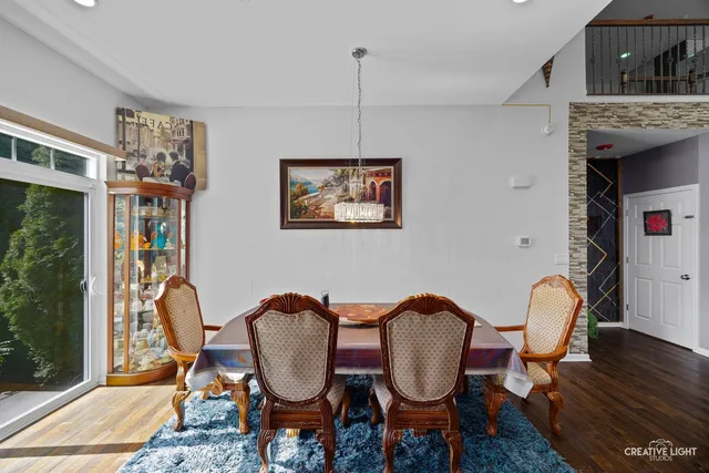 a dining room with furniture a chandelier and wooden floor