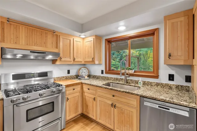 a kitchen with a sink stove top oven and cabinets