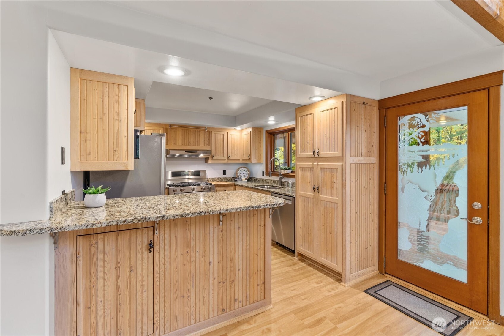 14012 Ingraham Road Monroe, WA 98272 - Photo 13 of 40 a kitchen with stainless steel appliances granite countertop a refrigerator a sink dishwasher and white cabinets with wooden floor