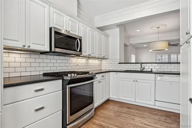 a kitchen with granite countertop white cabinets and white appliances