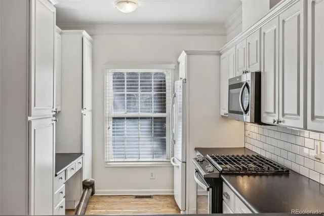 an empty room with wooden floor ceiling fan and windows