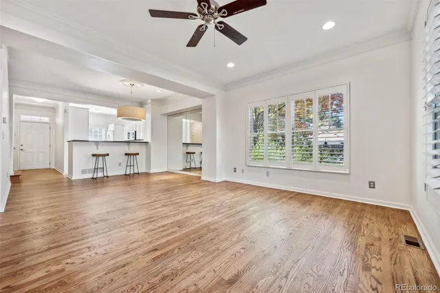 an empty room with windows fireplace and wooden floor
