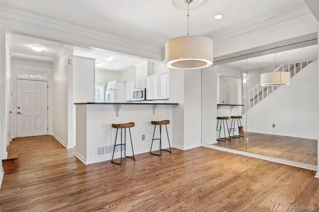 a view of a livingroom with a fireplace a ceiling fan and windows