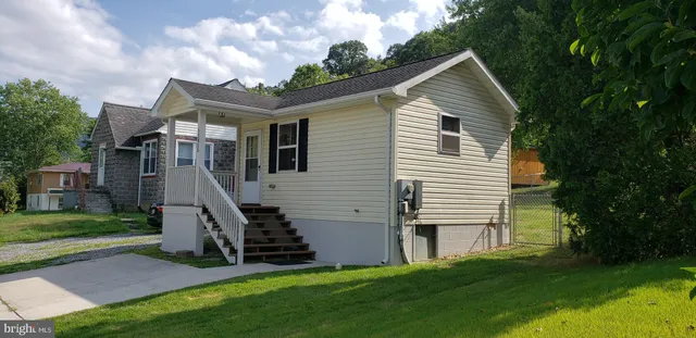 a front view of house with a garden and deck