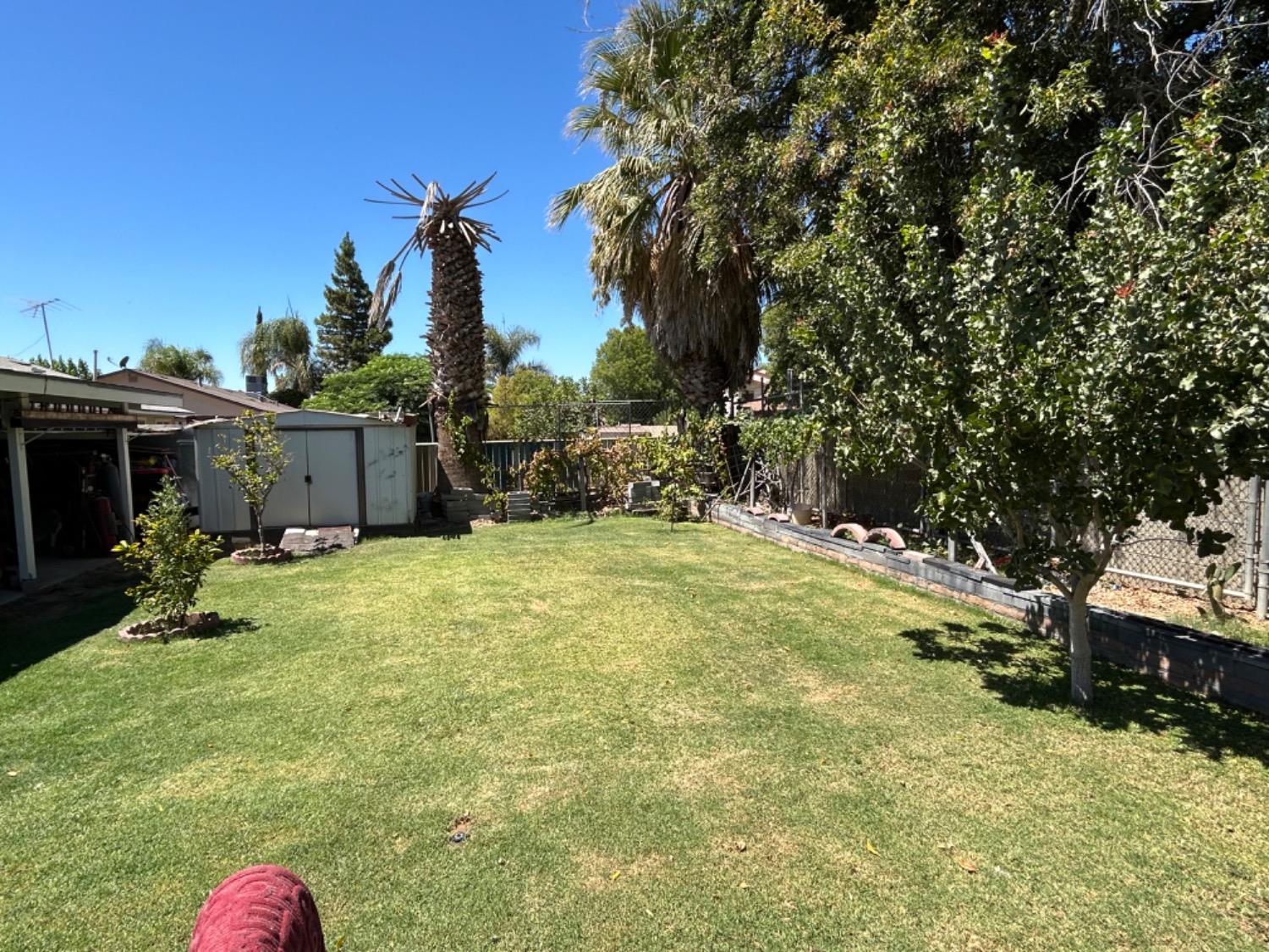 355 J Street Mendota, CA 93640 - Photo 19 of 21 a backyard of a house with table and chairs plants and large trees