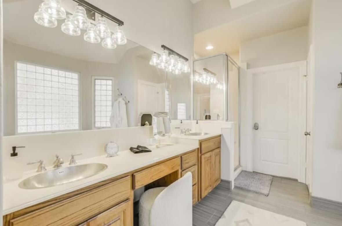 413 Breakaway Road Cedar Park, TX 78613 - Photo 14 of 21 Full bathroom featuring a shower stall, double vanity, and suspended lighting
