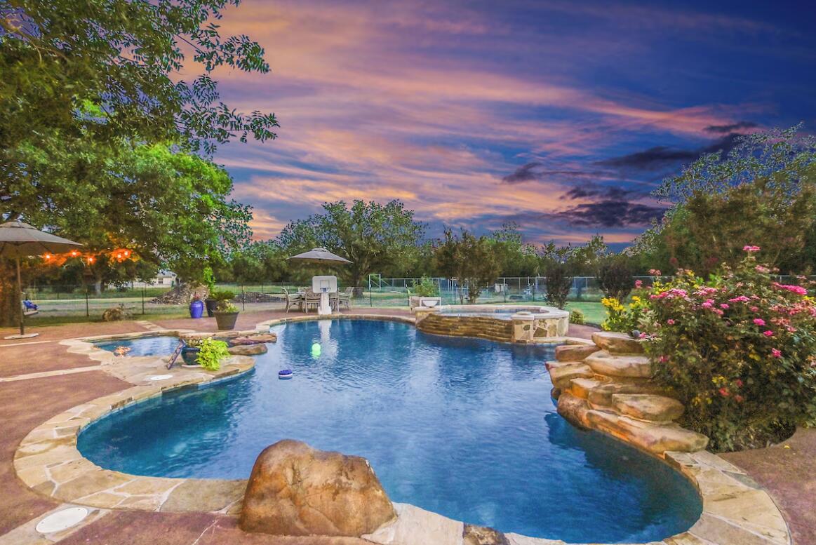 413 Breakaway Road Cedar Park, TX 78613 - Photo 4 of 21 Pool at dusk with a fenced backyard, a patio area, and a pool with connected hot tub