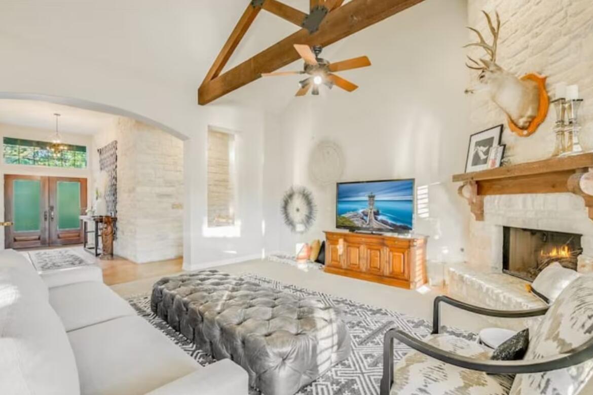 413 Breakaway Road Cedar Park, TX 78613 - Photo 7 of 21 Living room featuring french doors, arched walkways, a large fireplace, a ceiling fan, and lofted ceiling