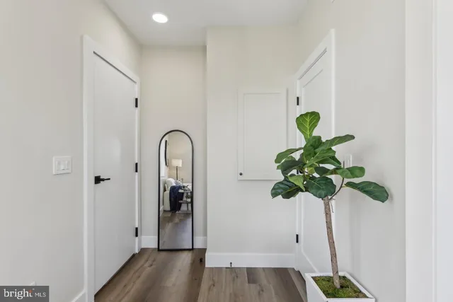 a view of a hallway with wooden floor and front door