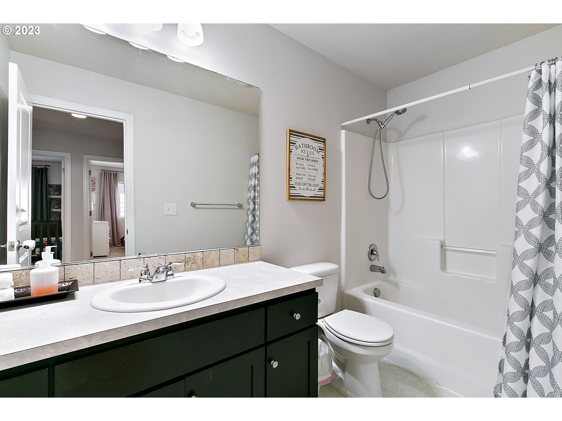 298 North 34th Court Ridgefield, WA 98642 - Photo 27 of 36 a bathroom with a sink a toilet a mirror a bathtub and shower