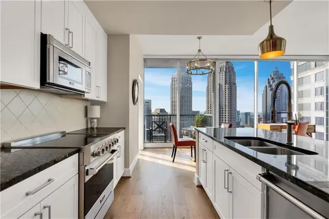a kitchen with stainless steel appliances granite countertop a sink a stove and a wooden floors