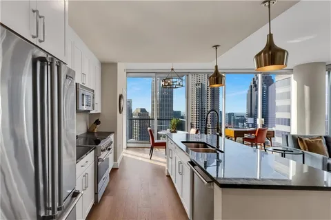 a kitchen with stainless steel appliances granite countertop a sink a stove and a refrigerator