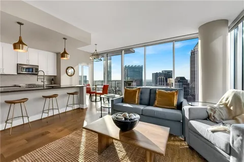 a living room with furniture wooden floor and a large window