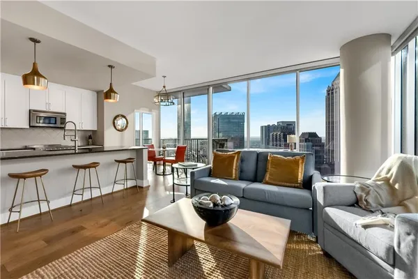 a living room with furniture wooden floor and a large window