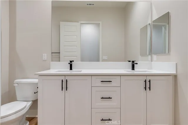 a bathroom with a sink a toilet and a mirror