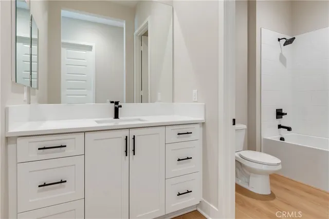 a bathroom with a sink a toilet a large mirror and shower