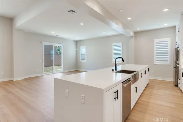 a large white kitchen with a sink and dishwasher