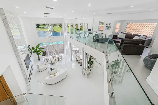 a kitchen with stainless steel appliances kitchen island granite countertop a refrigerator a sink a stove a dining table and chairs with wooden floor