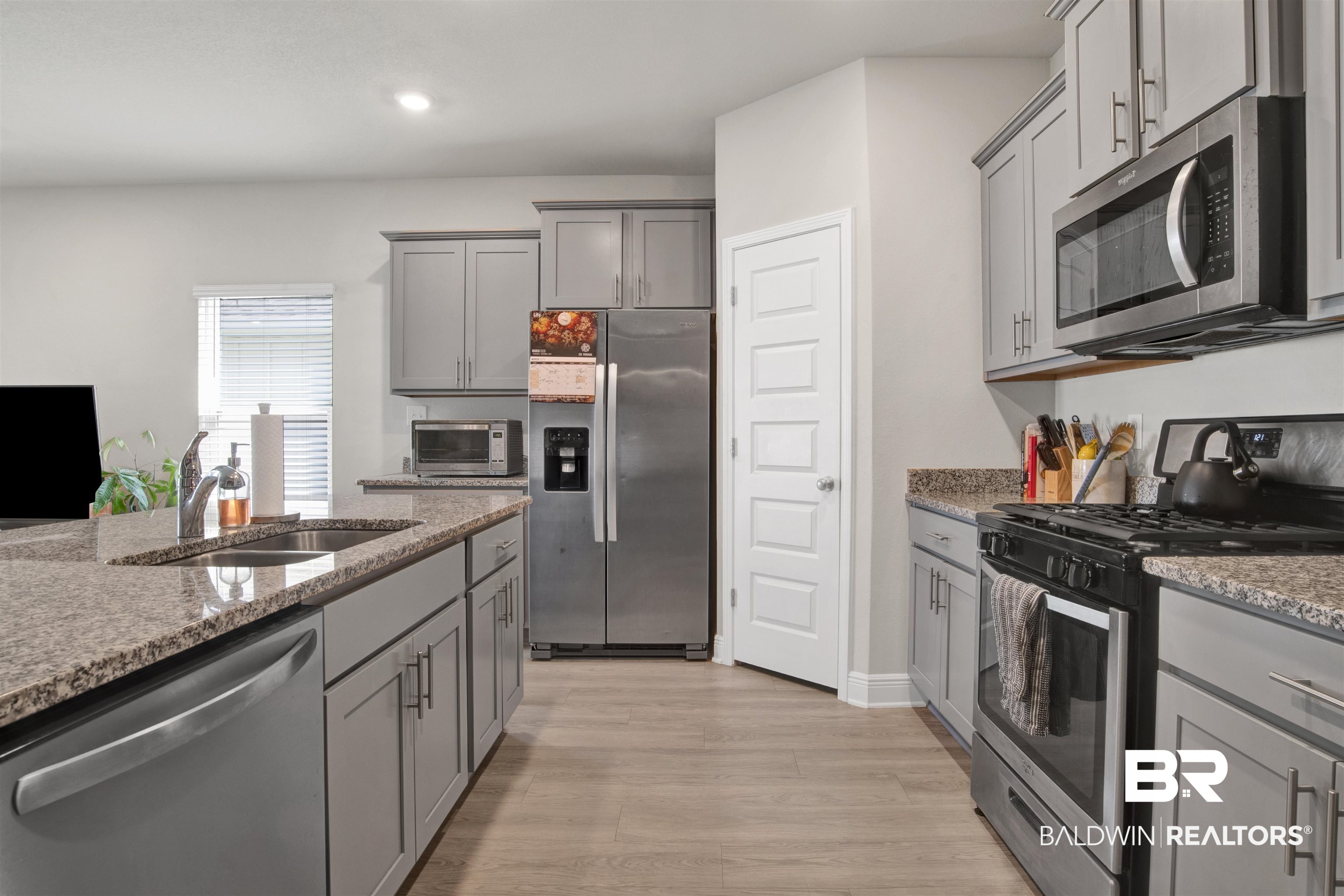 24253 Alydar Loop Daphne, AL 36526 - Photo 8 of 44 Kitchen with stainless steel appliances, gray cabinetry, light stone countertops, light wood-style flooring, and recessed lighting