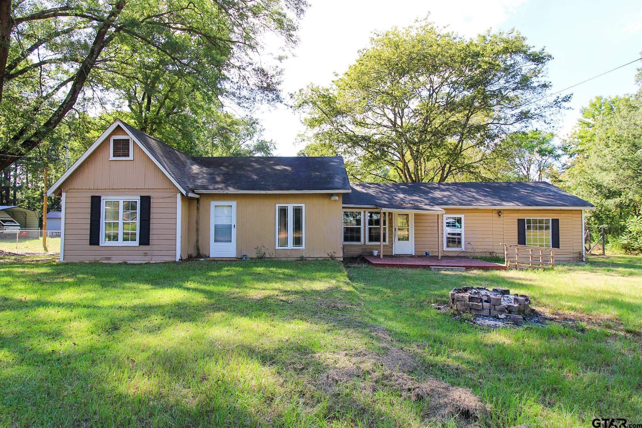 a front view of a house with a garden and trees
