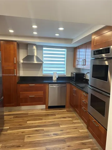 a kitchen with stainless steel appliances granite countertop a stove a sink and a microwave