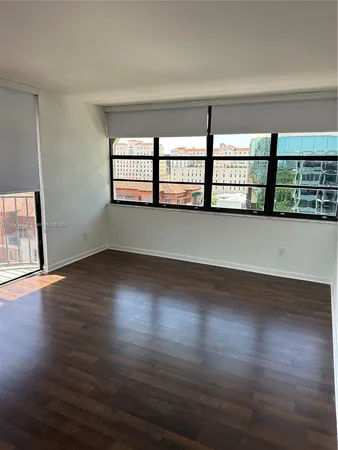 a view of a room with wooden floors and window