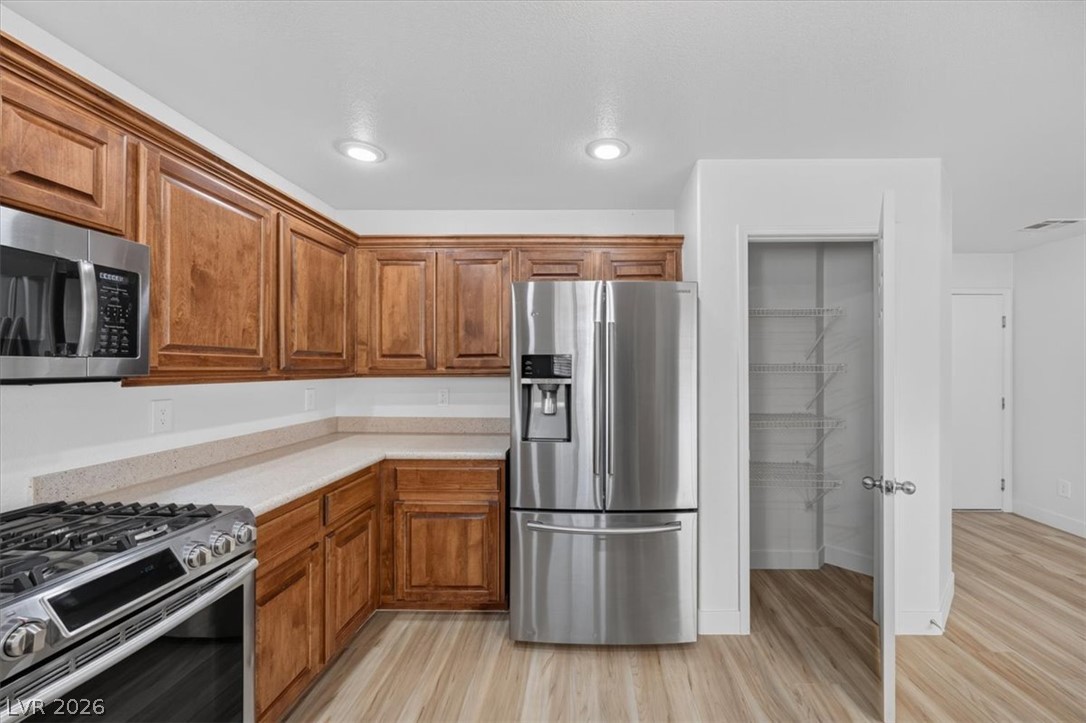 552 Albacate Street Henderson, NV 89015 - Photo 15 of 40 Culinary delights await in this modern kitchen with rich wood cabinetry and stainless steel appliances.