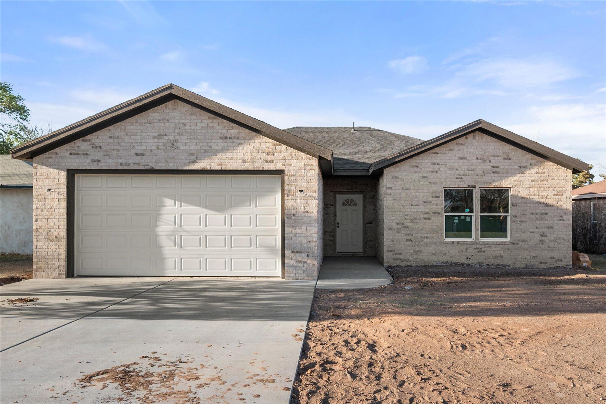 6412 38th Street Lubbock, TX 79407 - Photo 2 of 20 a front view of a house with a yard and garage