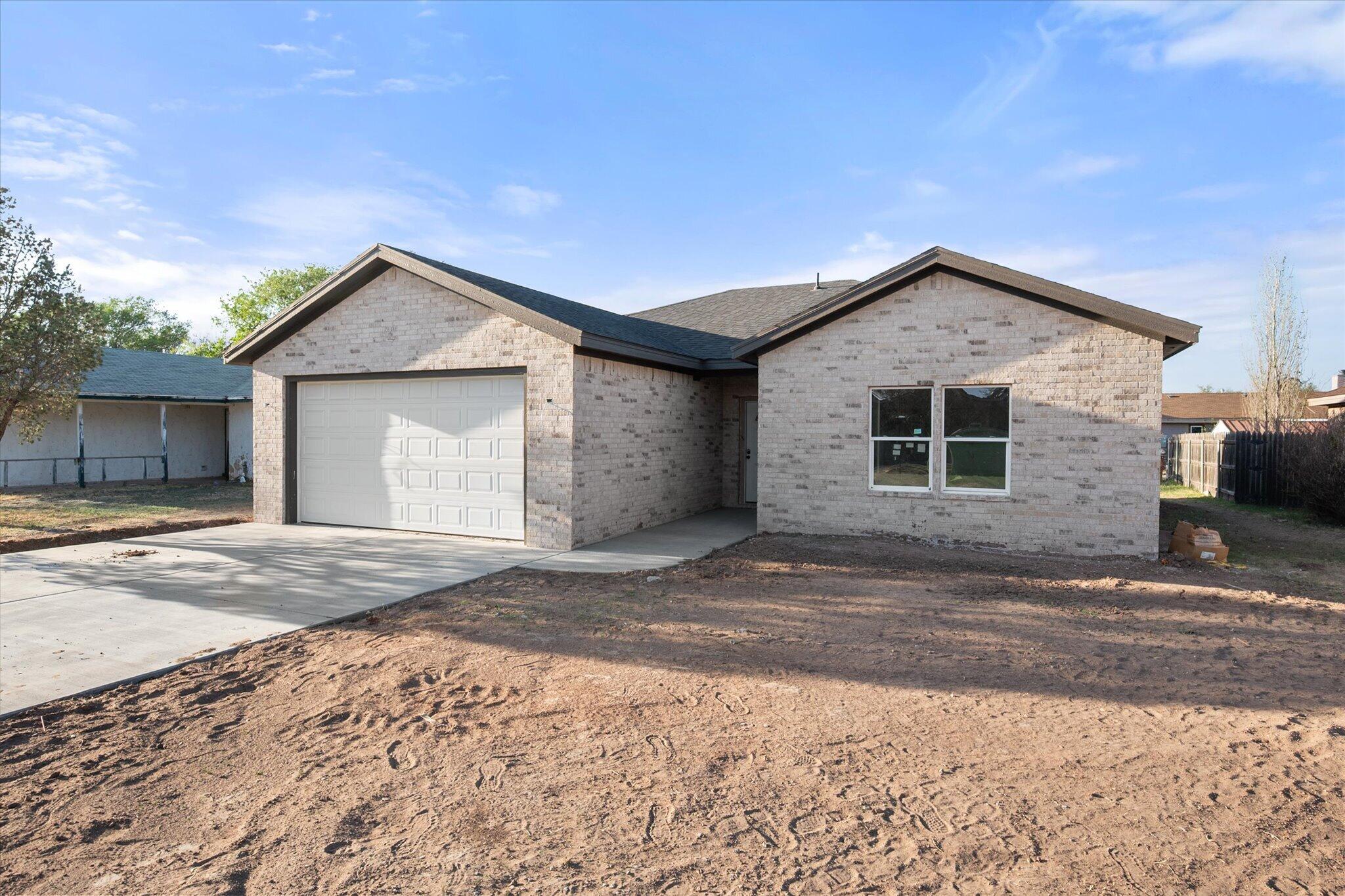 6412 38th Street Lubbock, TX 79407 - Photo 3 of 20 a front view of a house with a yard and garage