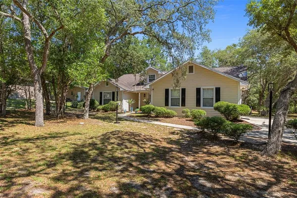 a front view of a house with a yard and trees