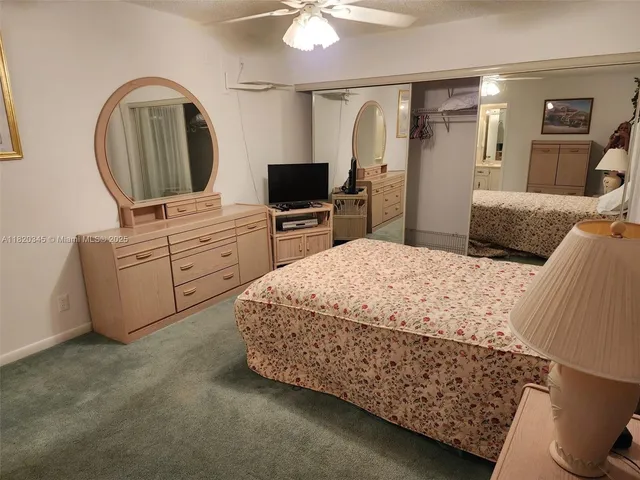 a bedroom with a bed a mirror on dresser and a chandelier