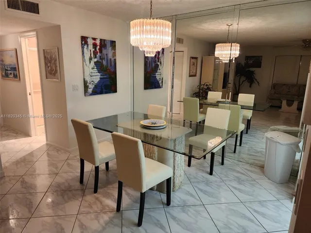 a view of a dining room with furniture and chandelier