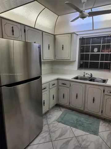 a kitchen with cabinets and refrigerator