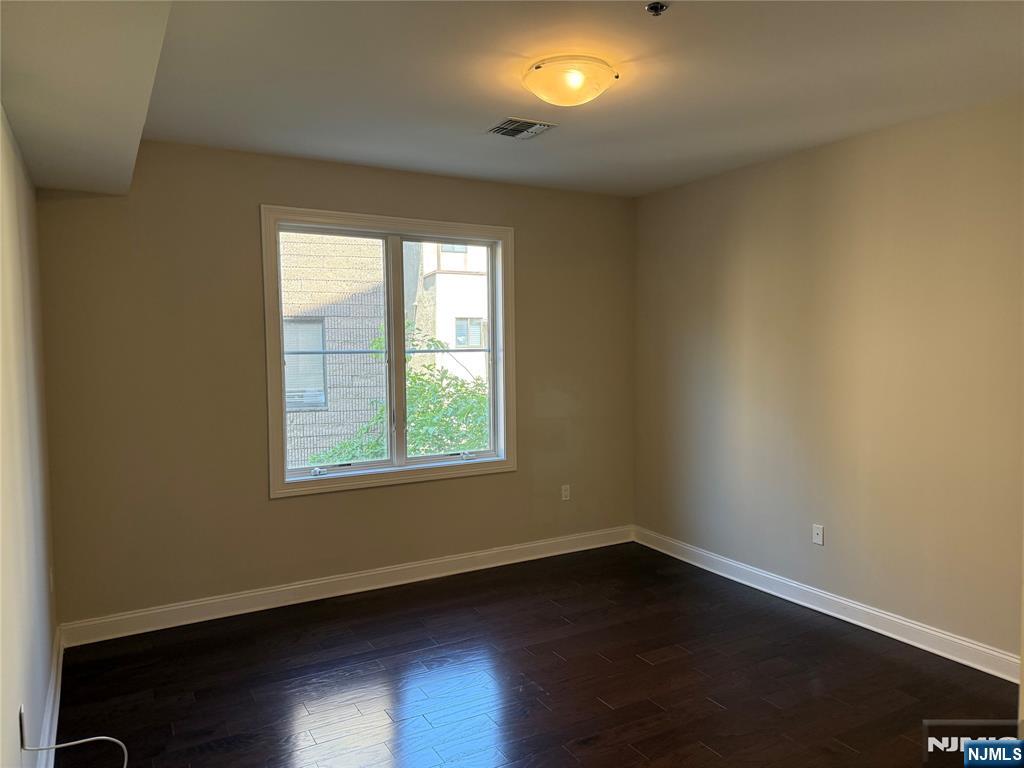 2001 Hudson Terrace, Unit 302 Fort Lee, NJ 07024 - Photo 6 of 16 an empty room with wooden floor and windows