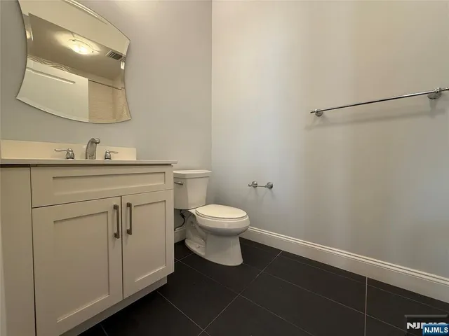 a bathroom with a toilet a sink a vanity and mirror