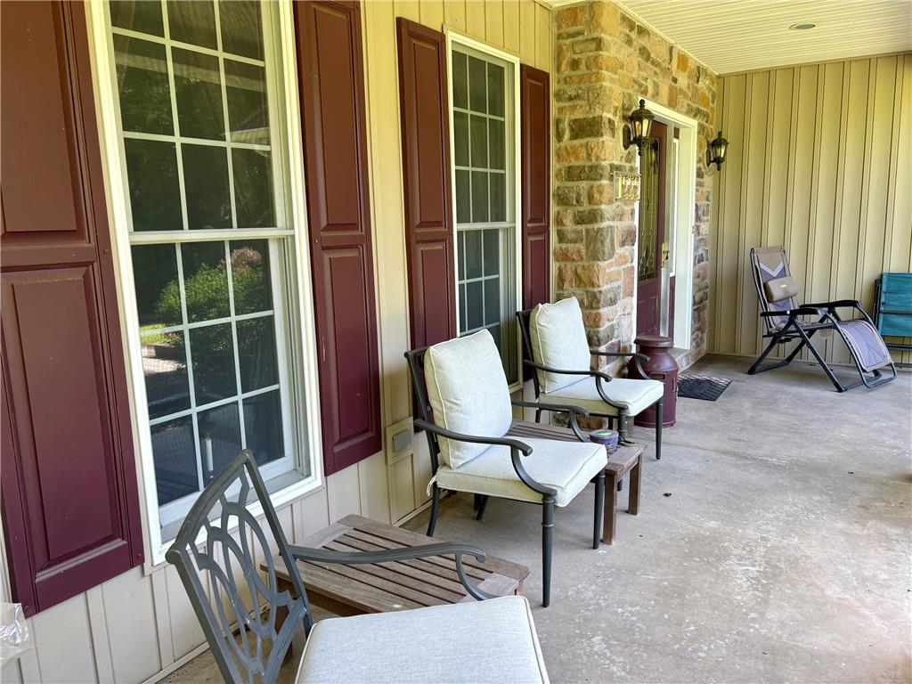 1222 Spring Road Andreas, PA 18211 - Photo 5 of 38 An inviting covered porch features ample space for outdoor seating and a stone facade accenting the entrance.