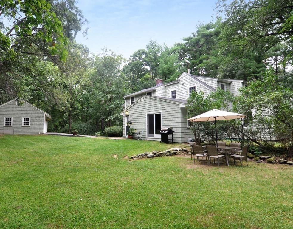 333 Depot Road Boxborough, MA 01719 - Photo 36 of 38 a backyard of a house with table and chairs under an umbrella
