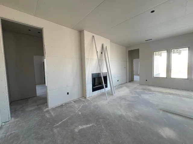 an empty room with a fireplace and windows