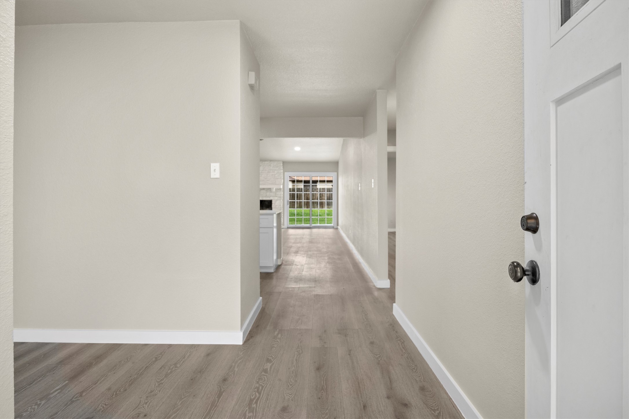 502 Pin Tail Lane Taylor, TX 76574 - Photo 7 of 26 Entryway featuring wood-finish flooring, light-toned wall paint, white baseboards, and a contemporary white door with dark hardware