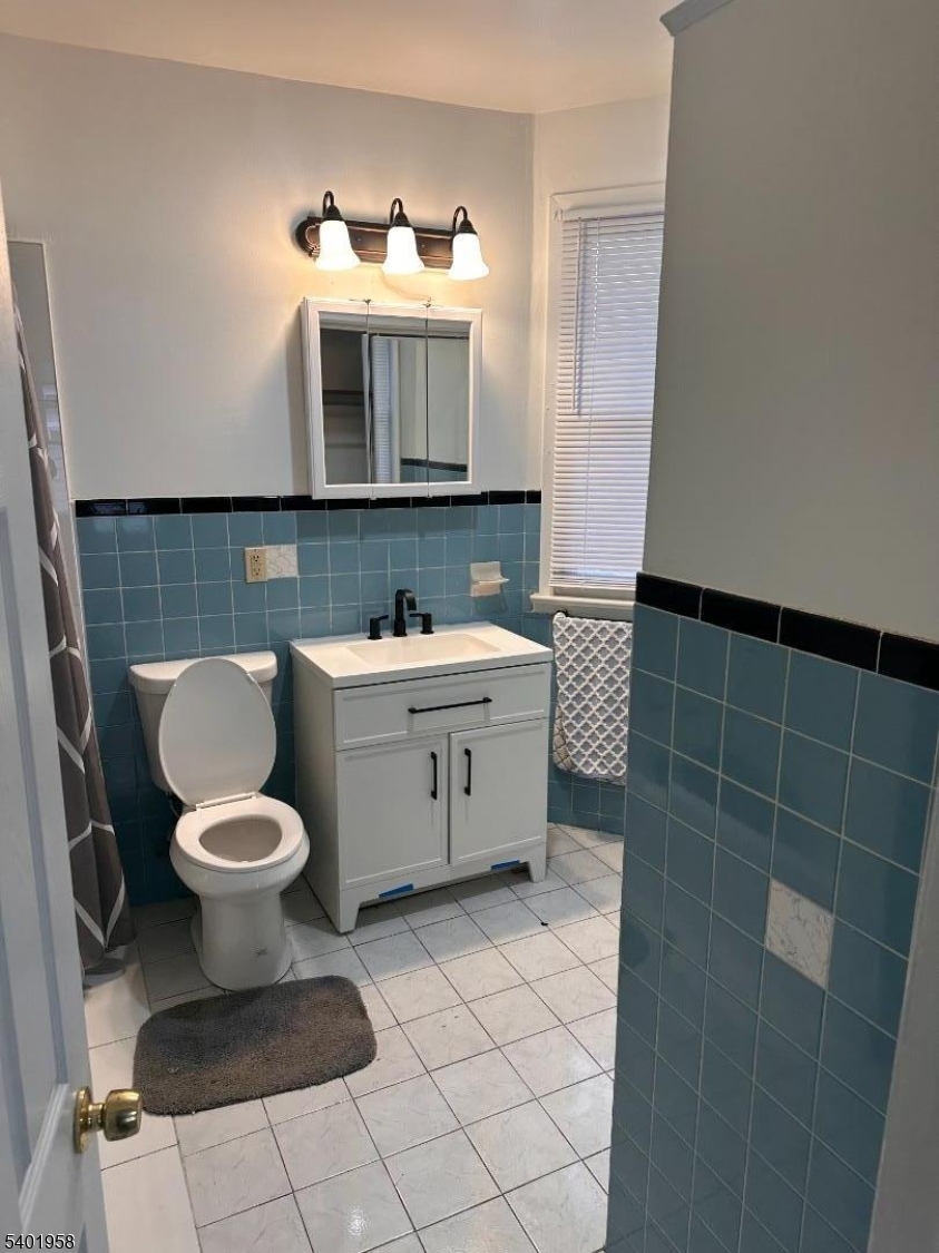 986 Madison Avenue Paterson, NJ 07501 - Photo 9 of 10 a bathroom with a sink toilet and mirror