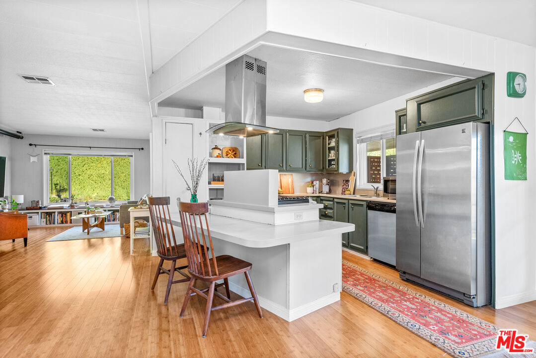 1205 Supi Topanga, CA 90290 - Photo 4 of 24 a kitchen with stainless steel appliances a dining table chairs refrigerator and sink