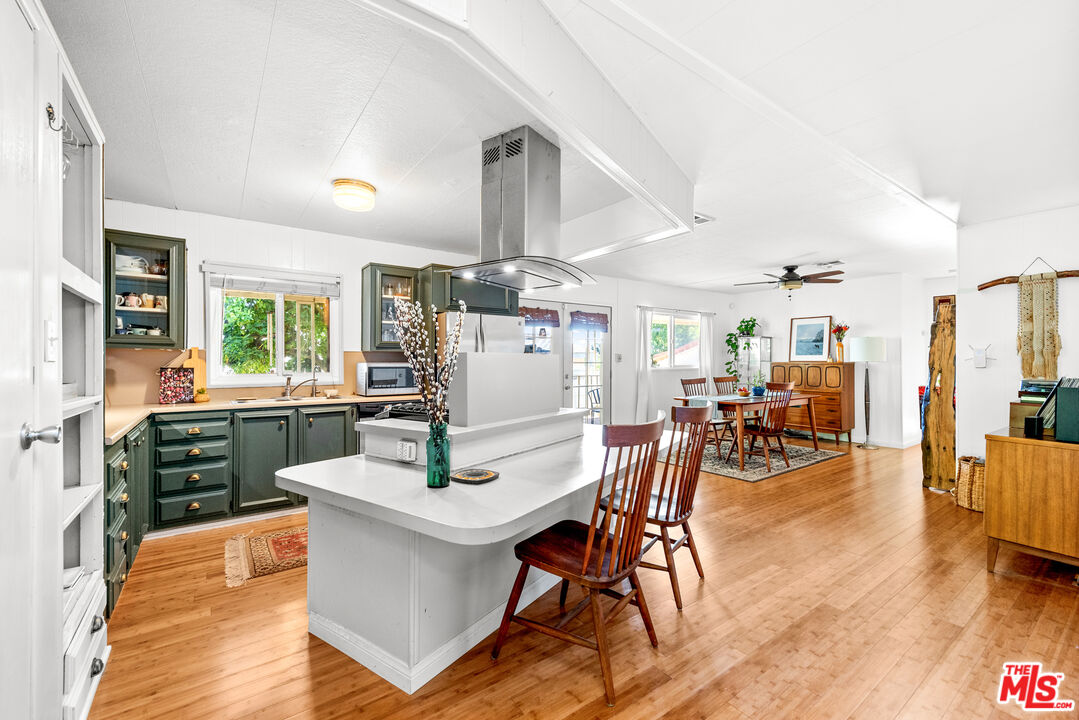 1205 Supi Topanga, CA 90290 - Photo 7 of 24 a kitchen with stainless steel appliances a dining table chairs and wooden floor