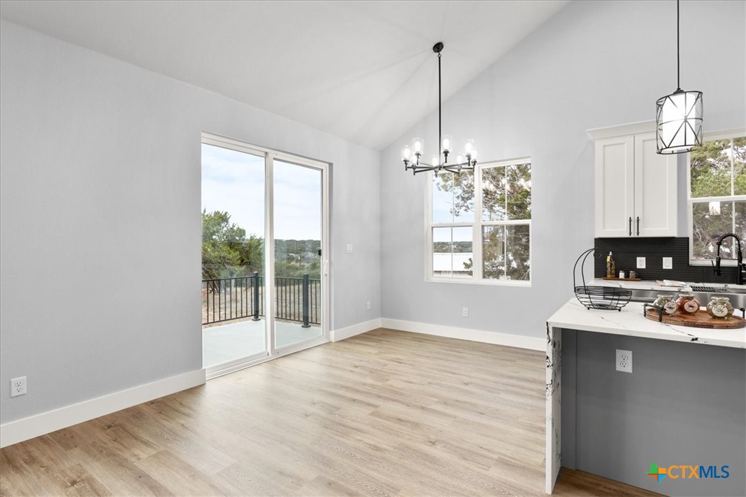 1190 Fernwood Road Fischer, TX 78623 - Photo 16 of 27 a view of a room with wooden floor chandeliers and kitchen view