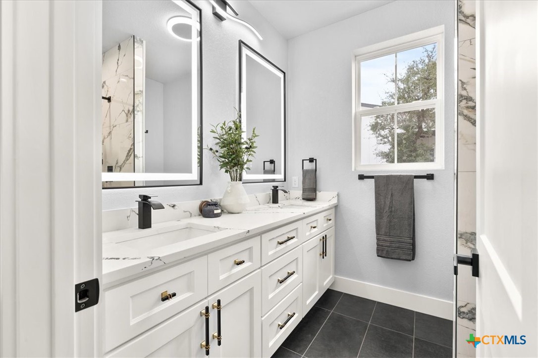 1190 Fernwood Road Fischer, TX 78623 - Photo 21 of 27 a bathroom with a double vanity sink a mirror and next to a window