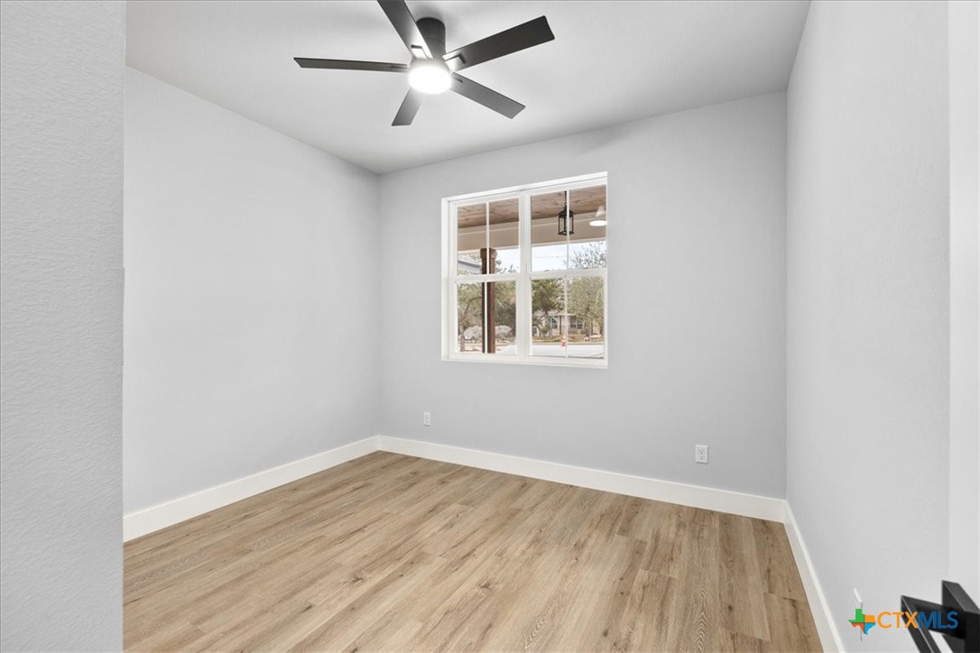 1190 Fernwood Road Fischer, TX 78623 - Photo 24 of 27 an empty room with wooden floor fan and windows