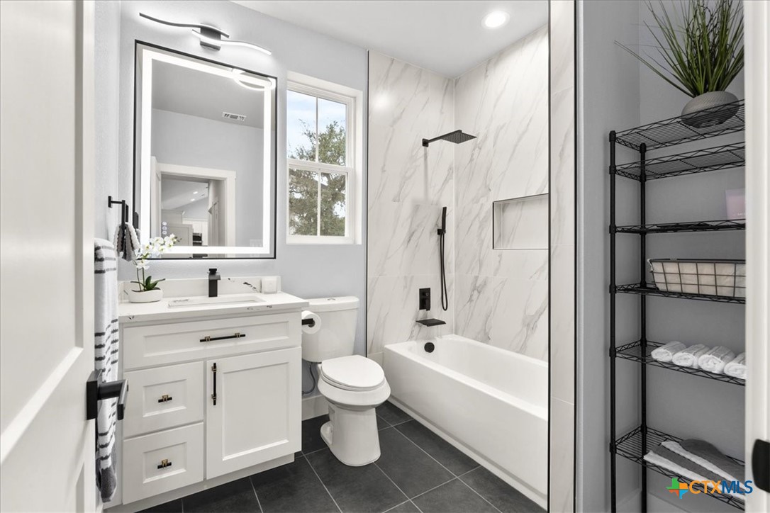 1190 Fernwood Road Fischer, TX 78623 - Photo 26 of 27 a bathroom with a bathtub toilet sink vanity and mirror