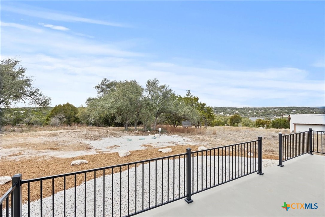 1190 Fernwood Road Fischer, TX 78623 - Photo 8 of 27 a view of a balcony with wooden floor and fence