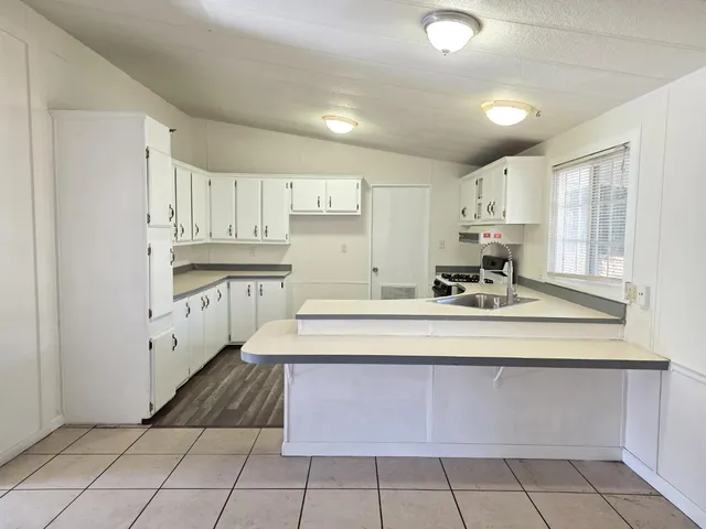 a kitchen with a sink window and cabinets