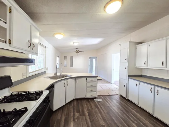 a large kitchen with stainless steel appliances granite countertop a stove and a sink
