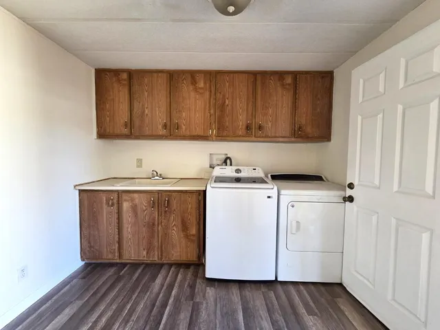 a utility room with wooden floor washer and dryer
